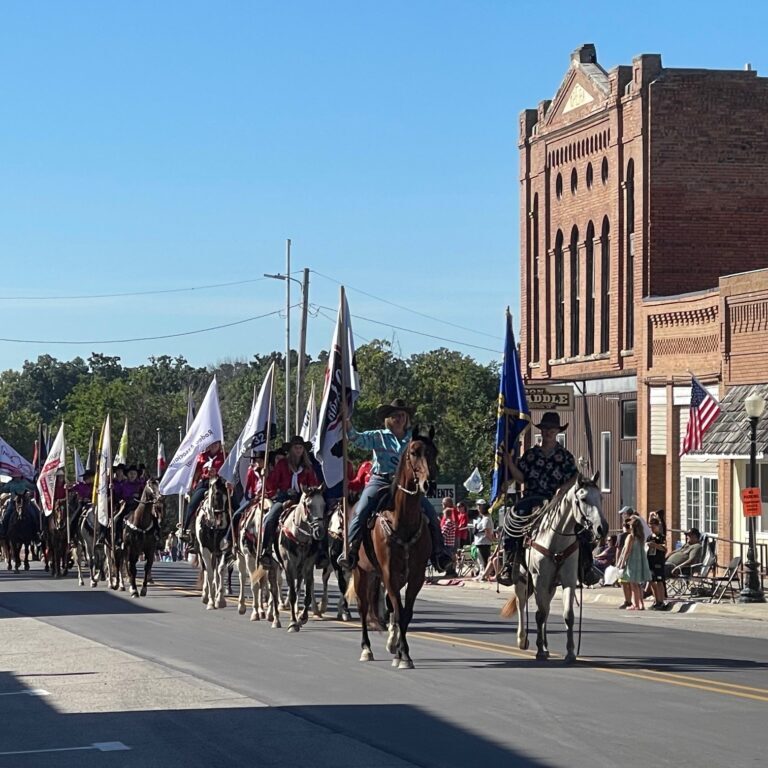 Labor Day parade down main street in Dayton, Iowa featuring saddle club members carrying flags